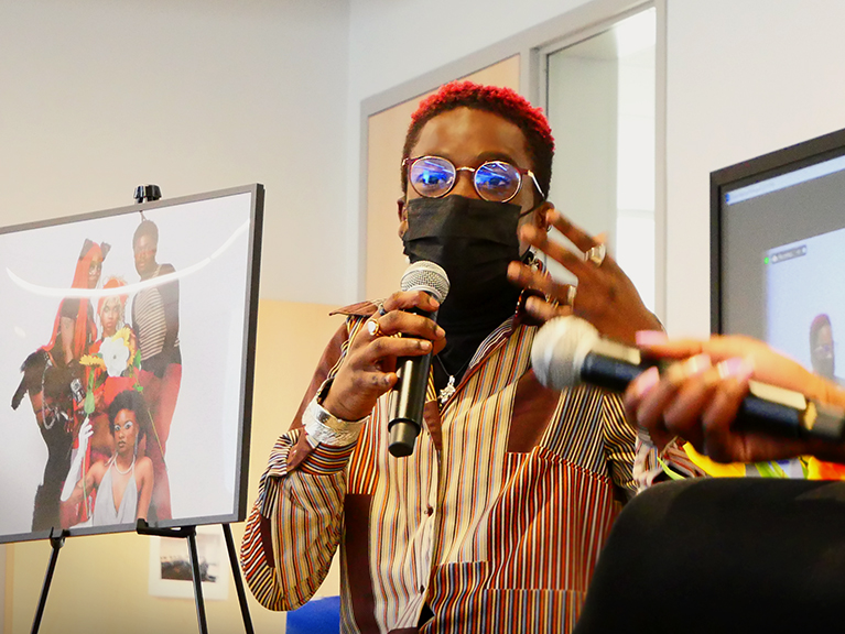 A person wearing a mask speaking into a microphone.